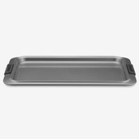A rectangular gray baking sheet with black silicone handles on each side.