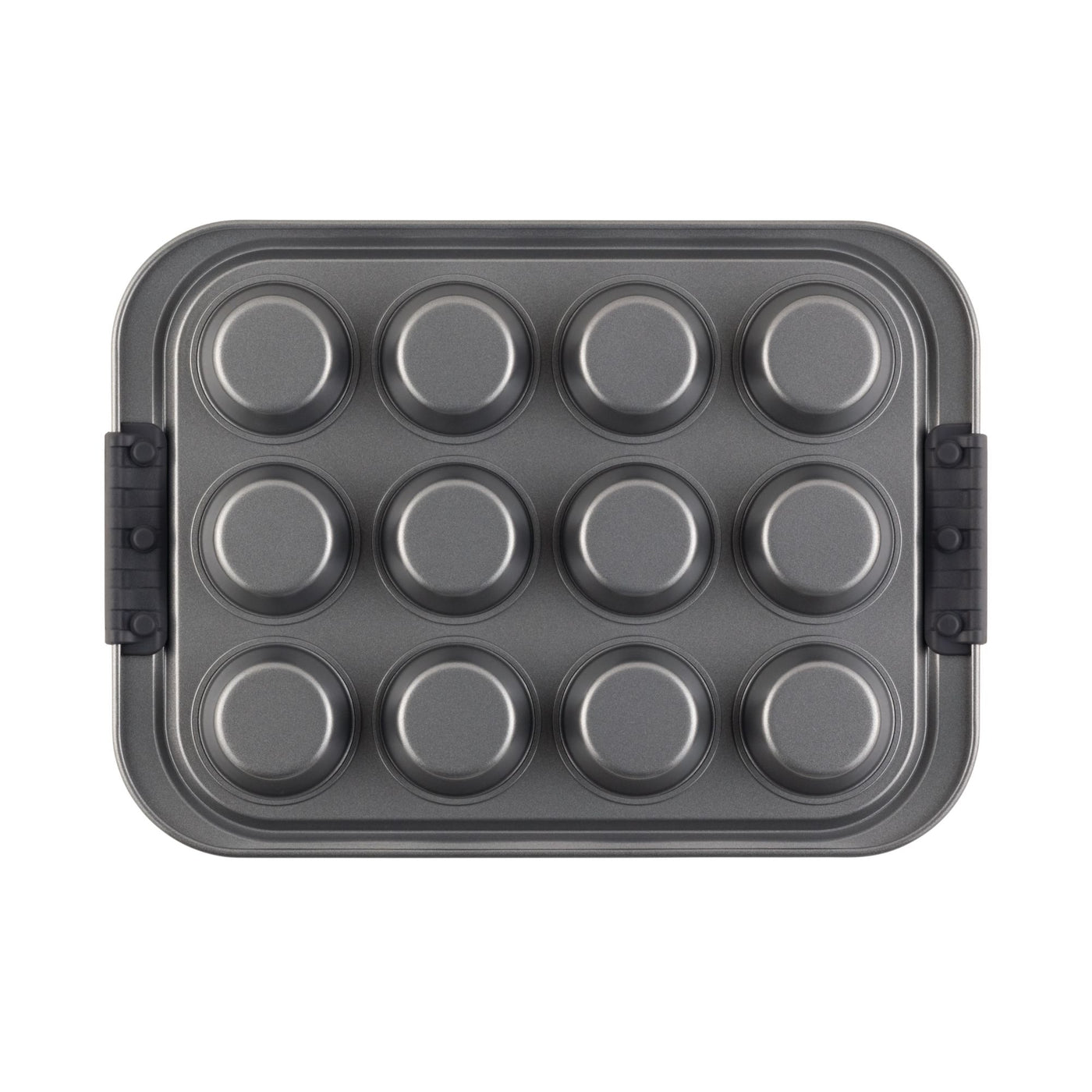 A metal muffin tin with twelve cup molds, placed in a rectangular baking pan with black side handles, viewed from above.