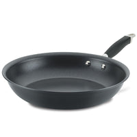 A black non-stick frying pan with a metal handle featuring a black grip, seen at a slight angle, isolated on a white background.