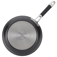 A non-stick frying pan with a stainless steel base, featuring a black exterior and a black handle. The brand name Anolon is engraved on the base, which also mentions it is dishwasher safe and made of suitable materials.