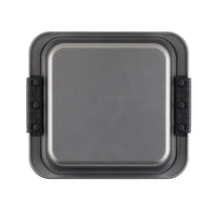 A square gray baking pan with a smooth surface and black handles on two opposite sides. The pan appears to be made of metal, suitable for baking cakes or other pastries.