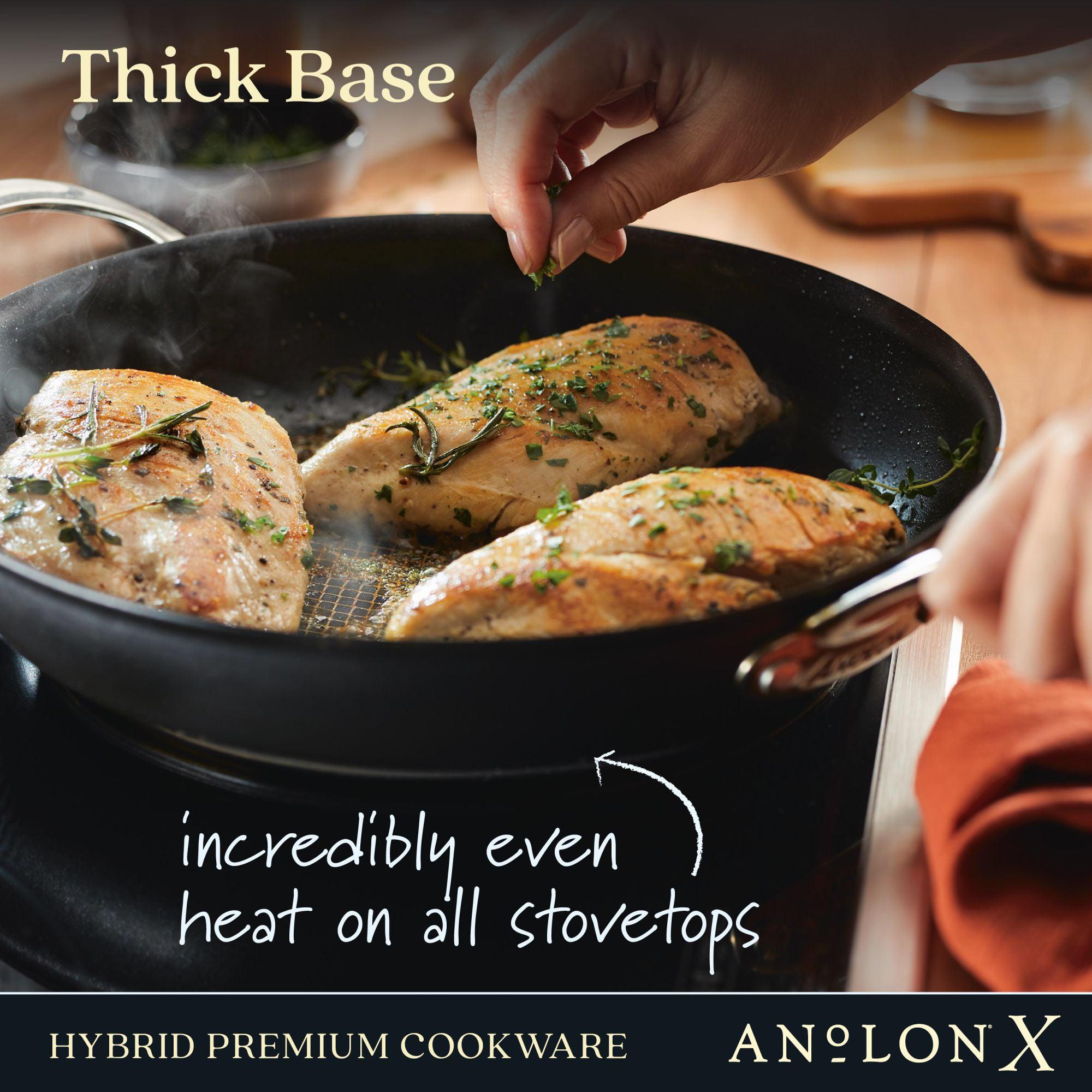 A hand cooks seasoned chicken breasts in the Anolon X 12-Inch Hybrid Nonstick Frying Pan with SearTech™ technology for even heat on all stovetops. Text: Thick Base, HYBRID PREMIUM COOKWARE, Anolon X.