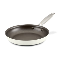 Introducing the Achieve 10-Inch Hard Anodized Nonstick Frying Pan, a robust kitchen essential with a sophisticated white exterior and dark interior. It boasts a metal handle, complete with a convenient hole for hanging, securely riveted for durability and ease of cleaning. An ideal addition to any kitchen, this frying pan is elegantly displayed on a white background.