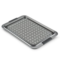The Advanced 10 x 15-Inch Crisper Pan Set features a nonstick metal roasting pan with a removable crisper insert, black silicone handles labeled "ANOLON," and raised edges for convenience and safety.