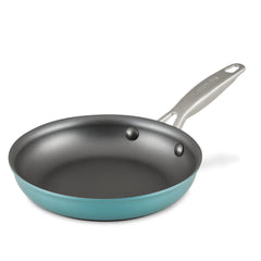 The Achieve 8.25-Inch Hard Anodized Nonstick Frying Pan is elegantly displayed on a white background, featuring a sleek blue exterior with a silver handle. Its ultra-durable black interior offers a smooth surface, secured by two rivets, providing effortless cooking and easy cleaning.