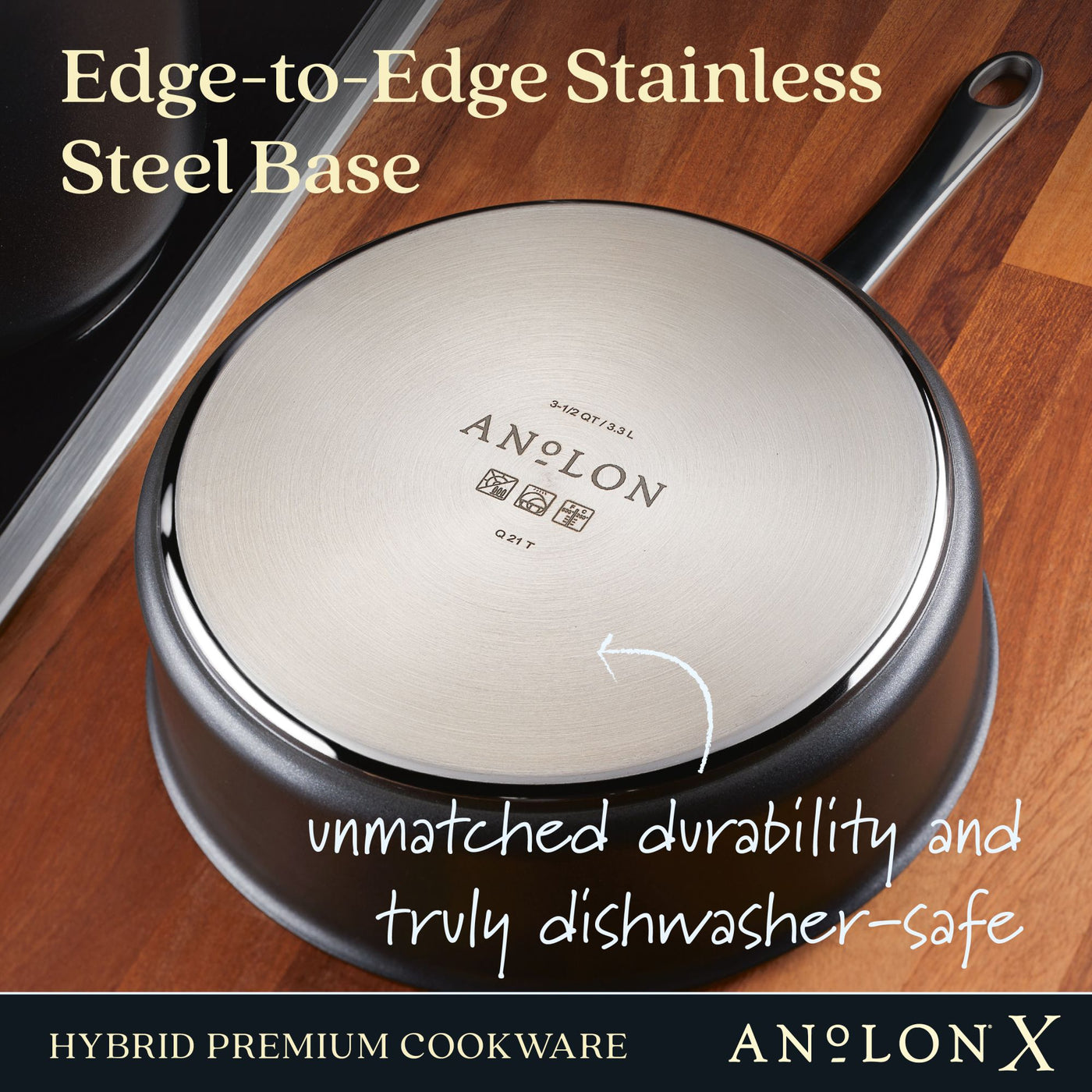 The Anolon X 3.5-Quart Hybrid Nonstick Induction Sauté Pan with Lid is shown upside down on a wooden surface, revealing its shiny Edge-to-Edge Stainless Steel Base. It offers unmatched durability, is truly dishwasher-safe, and features SearTech technology for versatile cooking on induction stovetops.