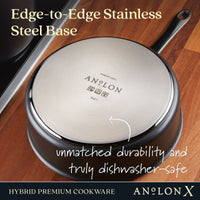 The Anolon X 3.5-Quart Hybrid Nonstick Induction Sauté Pan with Lid is shown upside down on a wooden surface, revealing its shiny Edge-to-Edge Stainless Steel Base. It offers unmatched durability, is truly dishwasher-safe, and features SearTech technology for versatile cooking on induction stovetops.