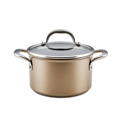 The Ascend 4-Quart Hard Anodized Nonstick Saucepot with Lid is a gold-colored pot featuring two handles and a glass lid. Crafted from hard-anodized aluminum, it boasts a sleek design with a nonstick finish and reflective stainless steel accents.