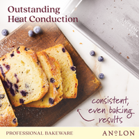 A sliced blueberry loaf rests on a wooden board next to the Pro-Bake 9-Inch x 5-Inch Aluminized Steel Loaf Pan. Text reads: Excellent heat conduction for consistent, even baking results. This professional bakeware is oven safe up to 550°F. A few scattered blueberries complete the scene.
