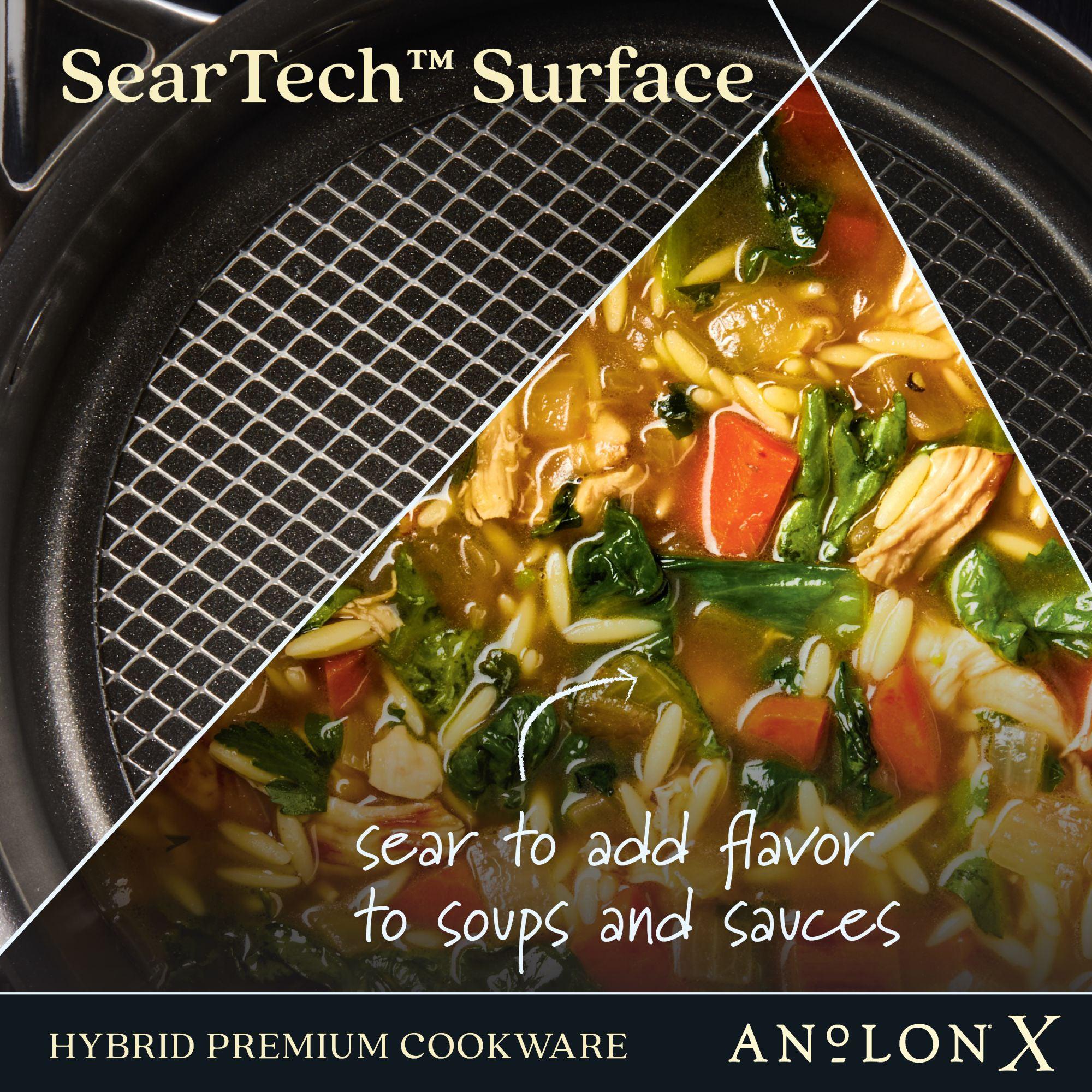 Close-up of Anolon Xs 3-Quart Hybrid Nonstick Saucepan With Lid, showing half with a textured nonstick surface and the other half with vegetable soup. Text reads, SearTech technology: sear to enhance flavor in soups and sauces—metal utensil safe.