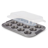 Introducing the Advanced Muffin Pan with Lid, designed to accommodate 12 muffins or cupcakes. This nonstick baking pan is crafted from heavy gauge steel for durability and features a partially open transparent plastic lid, along with two side handles for easy handling. It's perfect for ensuring your baked goods come out effortlessly every time.