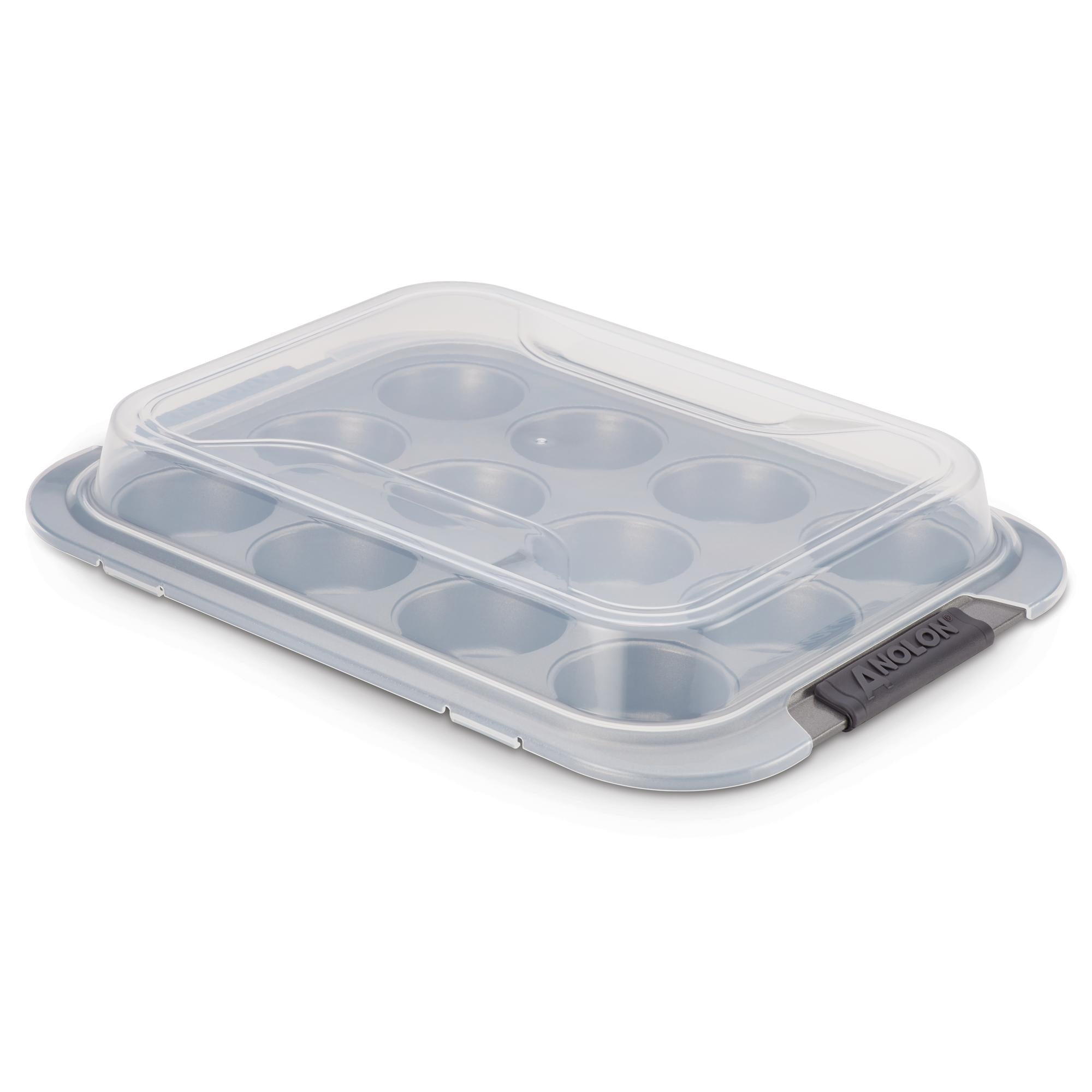 The Advanced Muffin Pan with Lid is designed with heavy gauge steel construction and features twelve slots for muffins. This gray nonstick pan comes with black handles on each side and includes a transparent plastic lid that fastens securely, ensuring your baked goods stay fresh.