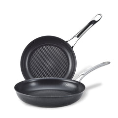 Two AnolonX 8.25-inch and 10-inch Hybrid Nonstick Frying Pans with silver handles are stacked crosswise, highlighting their SearTech technology. The textured cooking surfaces ensure excellent results, and the handles include holes for hanging. The image is set against a white background.