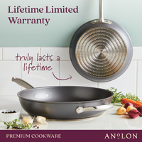 Two Accolade 10 & 12-Inch Frying Pans are shown in a kitchen, one flat with vegetables nearby and one hanging to display its precision forged base. Text reads Lifetime Limited Warranty—truly lasts a lifetime.