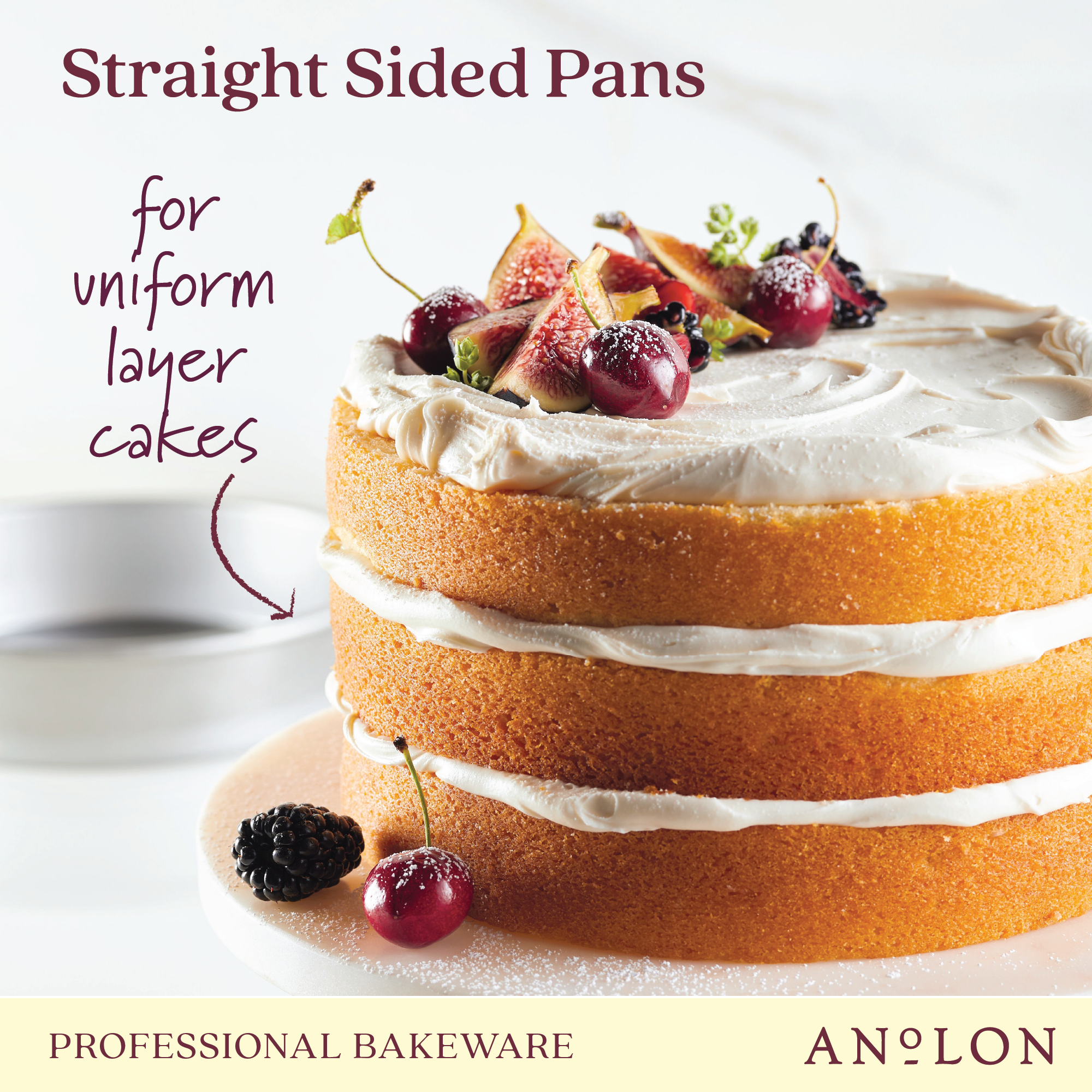 A three-layer cake with white frosting is adorned with figs and cherries. The text reads "9-Inch Aluminized Steel Round Cake Pan" by Pro-Bake in the bottom corner. Designed with premium aluminized steel, this pan guarantees even heat distribution for flawless results.
