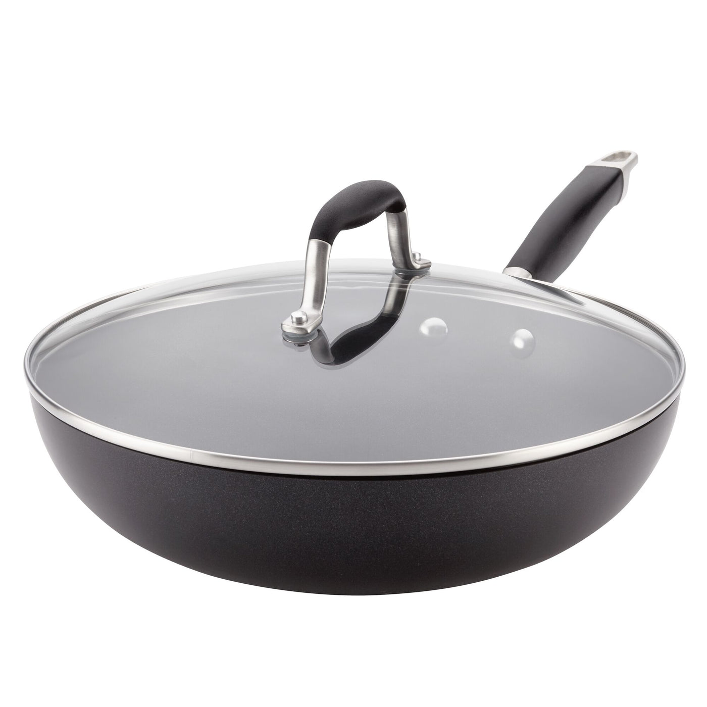 The Advanced Home collection includes the 12-Inch Ultimate Stir Fry Pan, a spacious black frying pan with a long handle and a clear glass lid. This hard-anodized pan features a metal rim around the lid and a black handle on top for easy lifting, while its own handle is adorned with an elegant silver end.