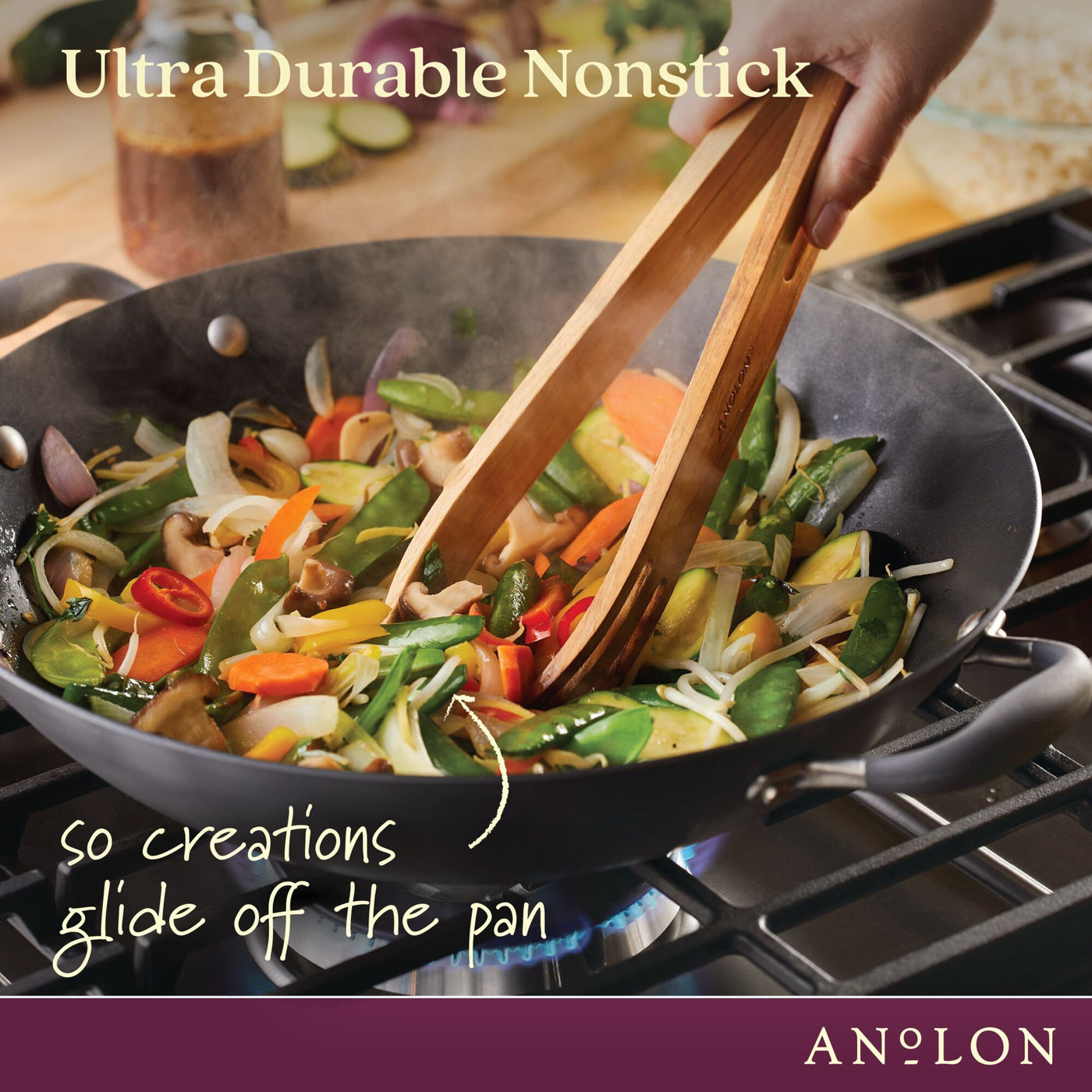 A person uses wooden tongs to stir-fry a colorful mix of vegetables in an Advanced Home 14-Inch Wok with Side Handles on the stove. The image highlights the ultra durability and nonstick quality of this hard-anodized flat bottom wok, showcasing the brand's commitment to excellence.