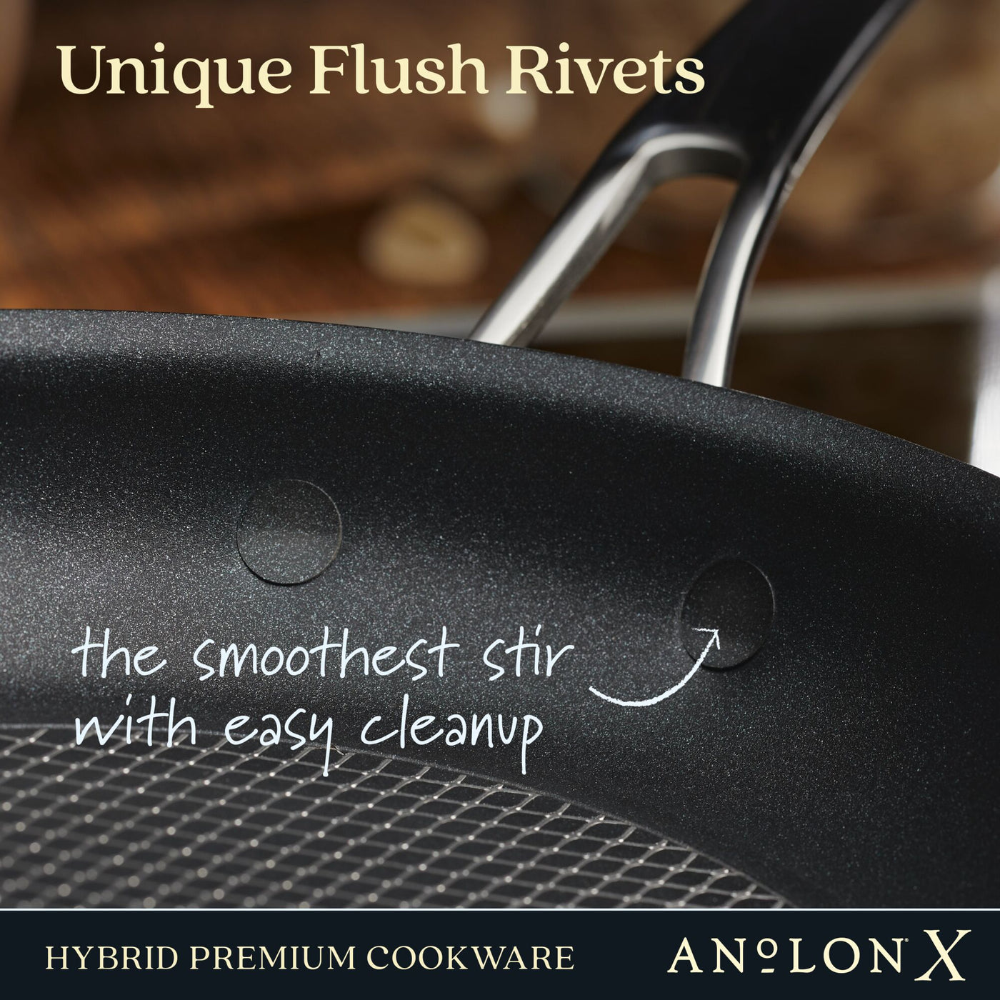 A close-up of a PFOA-free nonstick black frying pan highlights its flush rivets and SearTech™ surface for smooth stirring and easy cleanup. The blurred background emphasizes the interior, with text reading 10-Piece Hybrid Nonstick Cookware Set by Anolon X.