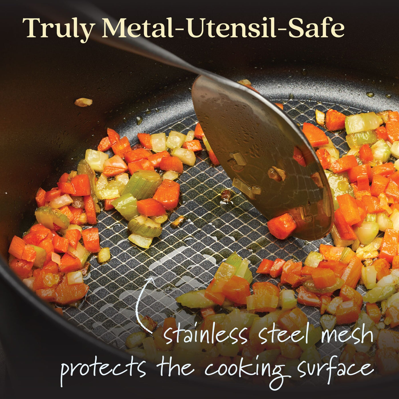 A spoon stirs chopped carrots, onions, and red peppers in the Anolon X 2.5-Quart Hybrid Nonstick Saucier Pan. Text reads: Truly Metal-Utensil-Safe and stainless steel mesh with SearTech™ technology protects the nonstick finish.