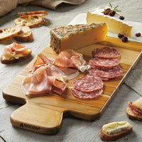 The Pantryware 19.5 x 8-Inch Cutting Board showcases cured meats, salami, prosciutto, a herbed cheese wedge, creamy cranberry cheese, and slices of bread with toppings arranged beautifully.