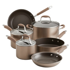 Introducing the 9-Piece Hard Anodized Nonstick Cookware Set by Advanced Home: this collection includes a range of essential kitchenware such as pots with lids, saucepans, and frying pans. Each piece boasts a sleek design with brown handles, providing both functionality and style, all showcased elegantly against a white background in bronze-colored perfection.