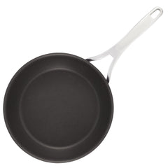 A frying pan from the Nouvelle Luxe 11-Piece Mixed Metals Cookware Set offers outstanding nonstick performance with its sleek black cooking surface and polished stainless steel handle, seen from above. The handle is designed with a hole at the end, making it ideal for hanging.