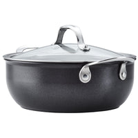 The Anolon X 4-Quart Hybrid Nonstick Casserole Pan features a black finish, ultra-durable nonstick surface, textured exterior, glass lid with metal handle, sturdy metal side handles, and a stainless steel base for even heat distribution. Its sleek design complements any modern kitchen.