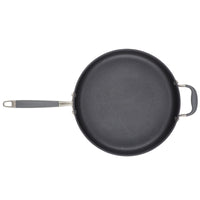 The 5-Quart Sauté Pan with Helper Handle by Advanced Home is a nonstick pan featuring a long handle and an additional smaller loop handle on the opposite side, set against a white background. Its dark interior surface has a smooth finish, ideal for even heating and effortless flipping.
