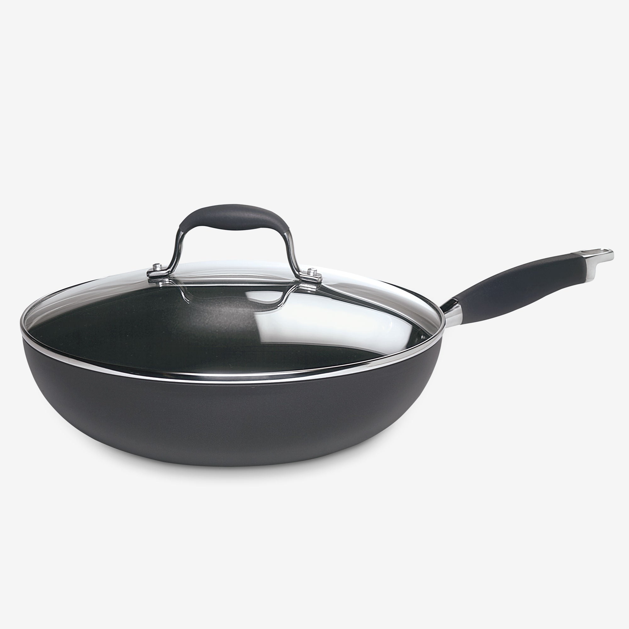 The Advanced 12-Inch Covered Ultimate Pan is a black nonstick stir fry pan with a long handle and clear glass lid, perfect for one-pan meals, shown on a white background.