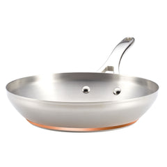 A Nouvelle Stainless 12-Inch Frying Pan with a copper bottom and sleek handle is shown isolated on a white background. The pan features a polished finish and two rivets securing the handle to its body.