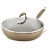 The 12-Inch Deep Nonstick Frying Pan with Lid by Advanced Home features a beige exterior and brown handle. Its high sides and hard anodized construction offer durability, while the glass lid's metal knob adds a modern touch to its sleek design.