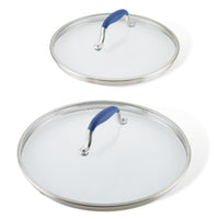 Two lids from the Advanced Home Lid Set, featuring glass with stainless steel edges and SureGrip® blue handles, are displayed. The replacement lids vary in size, with the smaller resting on top of the larger one. Both are shown from above against a plain white background.