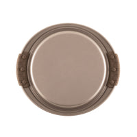 A 9-Inch Round Cake Pan with Silicone Grips by Advanced, in beige, is viewed from above. It features two brown handles with silicone grips and a simple, smooth surface, making it ideal for baking or cooking purposes.