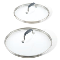 Two glass lids from the Anolon Advanced Home Lid Set boast stainless steel rims and SureGrip® handles in sleek black. The smaller lid is set above the larger one, both beautifully displayed against a white background.