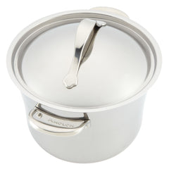 A glossy stainless steel pot from the Nouvelle Luxe brand's 11-Piece Mixed Metals Cookware Set offers nonstick performance and includes a lid with a curved handle, along with sturdy handles on either side. The brand name is delicately engraved on one of these handles.