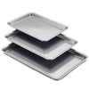 The 3-Piece Gourmet Cookie Pan Set by Gourmet consists of three stainless steel baking trays, ideal for homemade cookies, stacked with each measuring slightly larger than the one above it. These nonstick baking pans feature a smooth, shiny surface and raised edges.