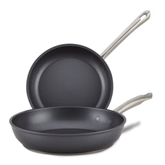 Displayed are the 8" & 10" Frying Pans from Accolade, with one lying flat and the other propped upright. They feature sleek, long handles and a smooth, dark interior. Crafted with precision-forged quality, these pans have a sapphire-reinforced coating for durable and effortless cooking every time.