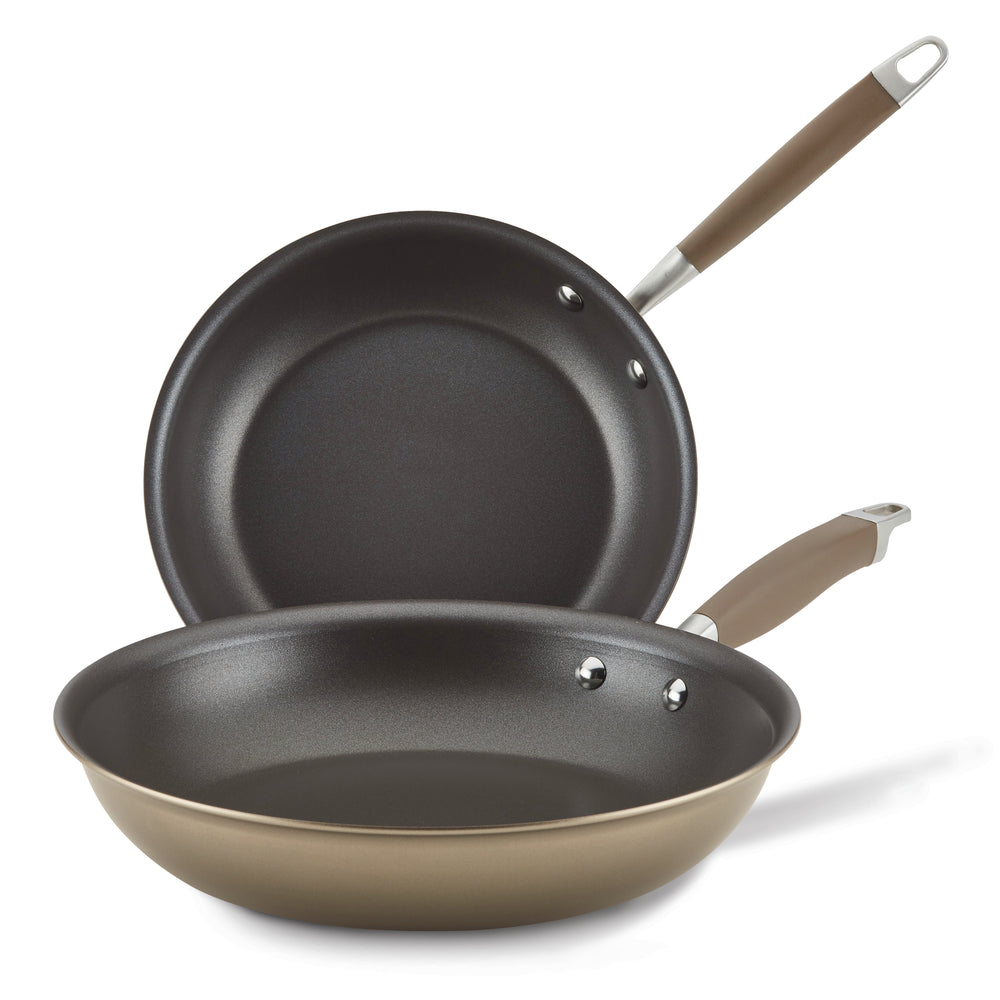 Two frying pans from the Advanced Home 10.25" & 12.75" Frying Pan Set, featuring a durable hard-anodized aluminum construction and stylish brown handles, are positioned against a white background. One pan is laid flat, while the other is angled to showcase its sleek nonstick interior, ideal for efficient cooking.