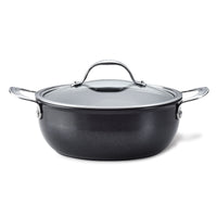 The Anolon X 4-Quart Hybrid Nonstick Casserole Pan showcases a sleek black design with a durable nonstick finish, a glass lid, metal handles, and a stainless steel base, set against a plain white background.