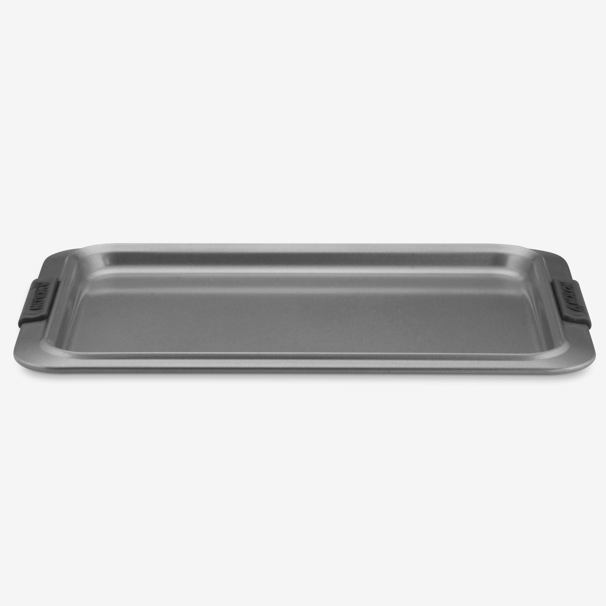 The Cookie Sheet with Silicone Grips by Advanced is a rectangular non-stick pan featuring dark gray silicone grips on each side, contrasting with a light gray background. It offers even heat distribution and has a flat surface with raised edges designed for optimal baking and easy handling.