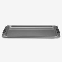 The Advanced Cookie Sheet with Silicone Grips is a rectangular, non-stick pan designed for even heat distribution, featuring raised edges and silicone grips on the sides, all displayed against a plain white background.
