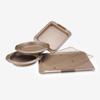 Introducing the Advanced 5-Piece Bakeware Set, featuring a collection of five golden-brown pans and racks. This set includes two round cake pans ideal for baking banana nut bread, a rectangular pan perfect for bar cookies, along with a cooling rack and a baking sheet. All pieces are elegantly displayed on a light surface.