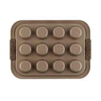Introducing the Advanced Muffin Pan with Lid: a rectangular metallic pan expertly constructed from heavy gauge steel. It features twelve nonstick molds and two side handles, ideal for baking muffins or cupcakes. This nonstick muffin pan is displayed on a pristine white background.