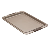 The Advanced Cookie Sheet with Silicone Grips features a rectangular nonstick design, raised edges for safety, and silicone grips for ease of handling. The beige sheet ensures even heat distribution, making it ideal for baking and roasting.