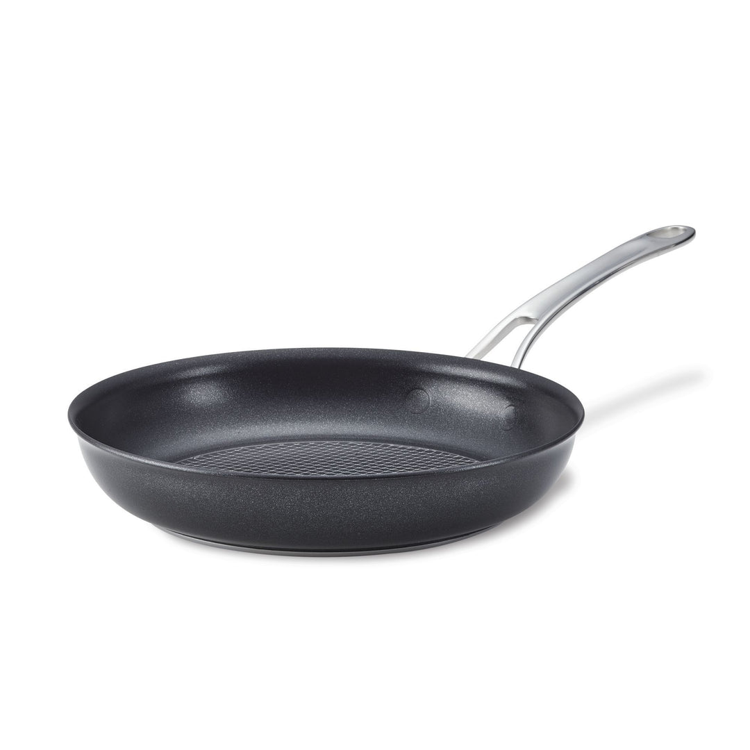 Black non-stick frying pan with a silver handle against a white background.